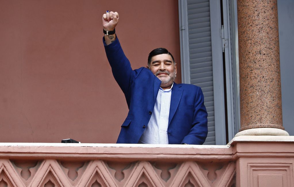 ARCHIVO - Diego Maradona saluda a la gente en la Casa Rosada, sede del gobierno de Argentina, tras una reunión con el presidente Alberto Fernández, el 26 de diciembre de 2019. (AP Foto/Marcos Brindicci)