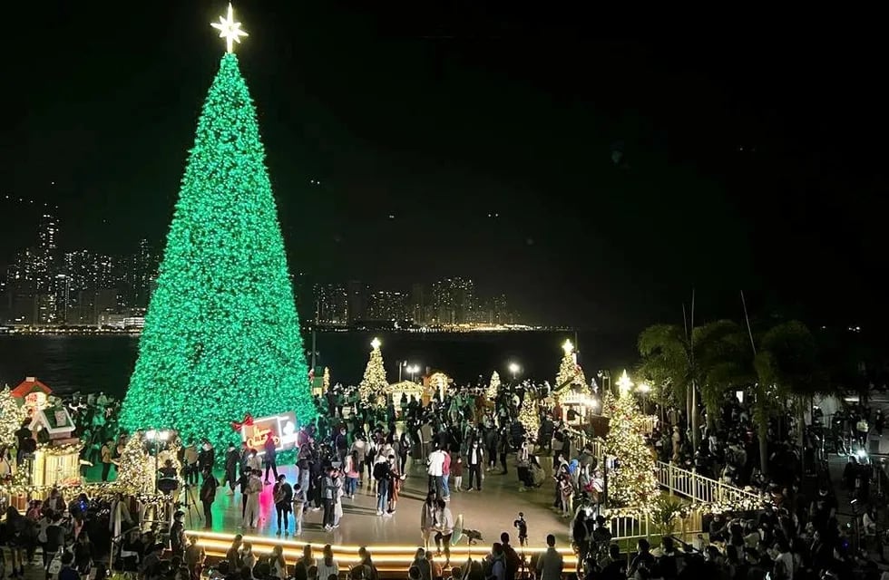 La gente se reunió en la víspera de Navidad en el árbol de Navidad más alto de 20 metros que se encuentra en los bordes del puerto Victoria en Hong Kong.