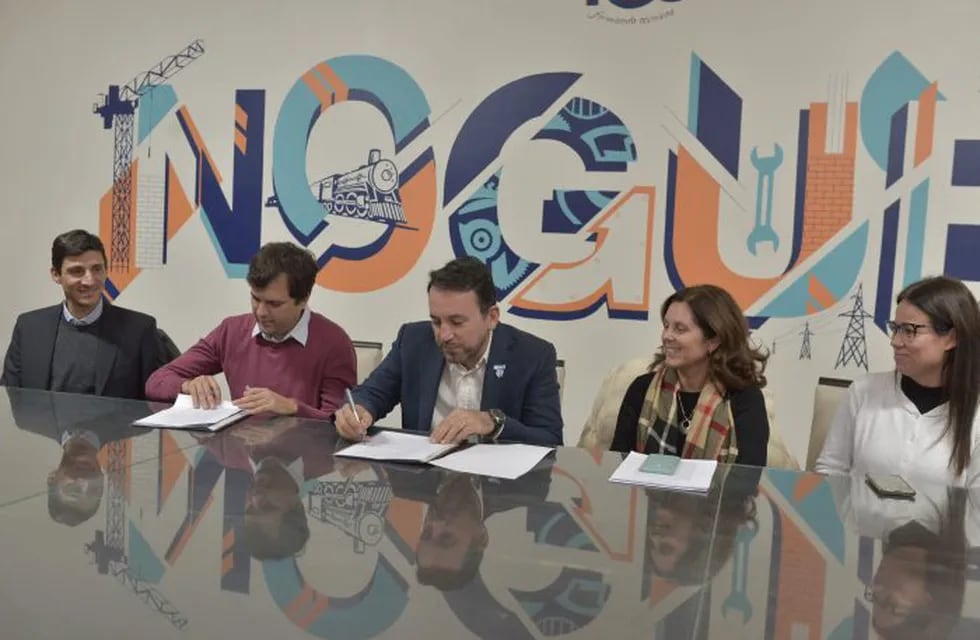 Miembros de Junios Achievement con el ministro Tadeo García Zalazar firmando el acuerdo.