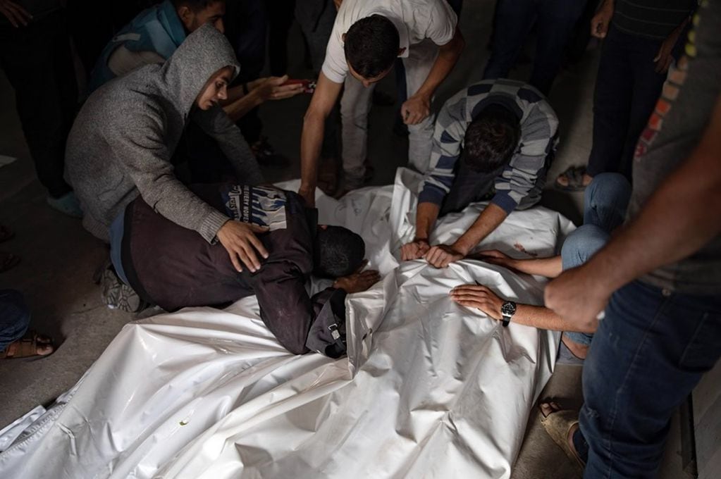 Palestinos lloran junto a los cuerpos de familiares muertos en el ataque israelí contra un campamento para desplazados en Rafah, en el sur de la Franja de Gaza, este 27 de mayo. EFE/EPA/Haitham Imad