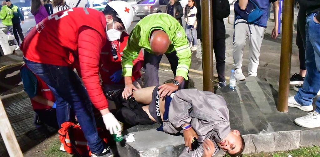 Miembros de Defensa Civil atienden a un herido en las inmediaciones del estadio de Gimnasia. / Gentileza: Clarín.