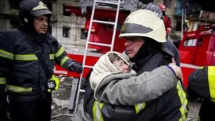 En esta foto publicada por el Servicio Estatal de Emergencias de Ucrania, un bombero abraza a una anciana después de ser evacuada de un edificio de apartamentos afectado por bombardeos en Kiev, Ucrania, el lunes 14 de marzo de 2022