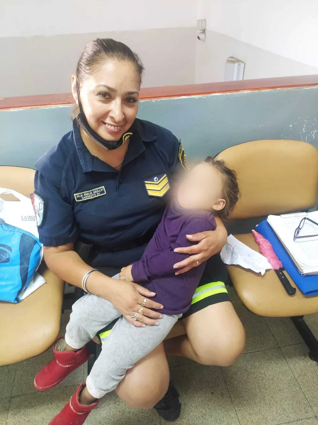 La niña duerme en brazos de la sargenta Analía Aballay, que la rescató del maltrato que sufría en su hogar.
