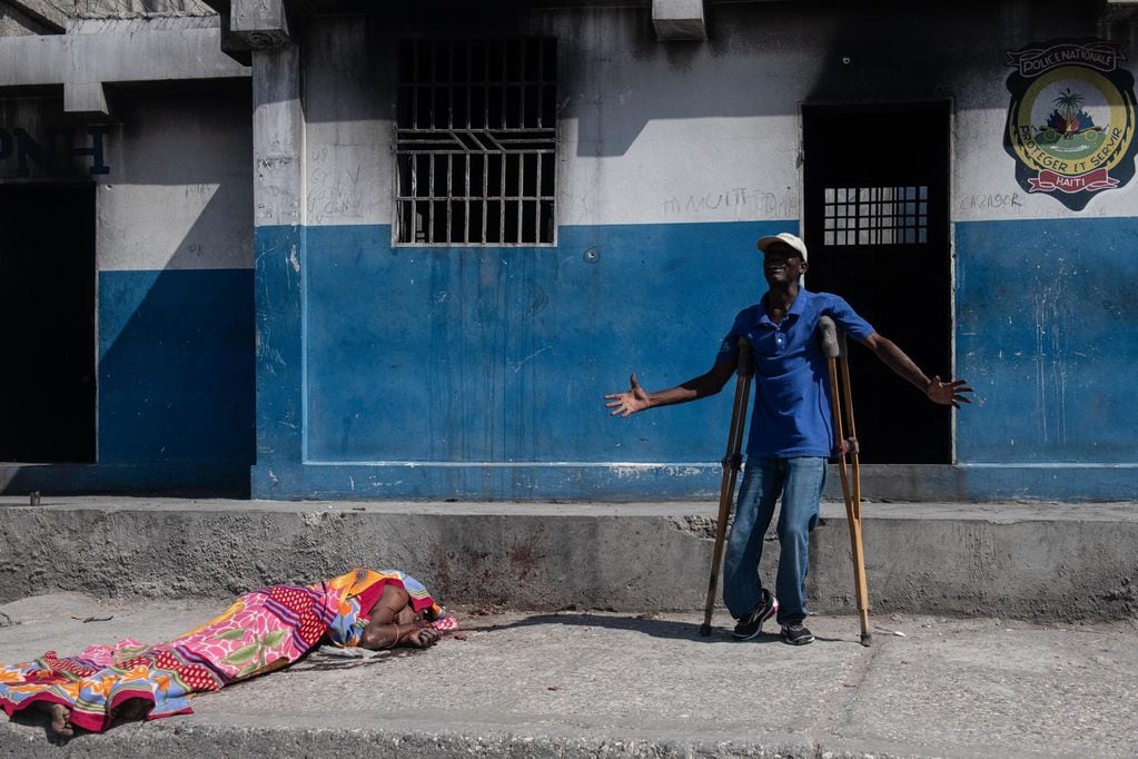 PUERTO PRÍNCIPE (HAITÍ), 05/03/2024.- Un hombre llora junto al cuerpo sin vida de un persona en los exteriores de la comisaría de Carrefour Aéroport, que fue incendiada la noche de ayer por miembros de pandillas, este martes, en Puerto Príncipe (Haití). Las calles de Puerto Príncipe muestran este martes una aparente normalidad tras los intensos tiroteos de la víspera, aunque en algunos puntos continúan apareciendo cadáveres. La población intenta recuperar la normalidad y se dedica a sus tareas cotidianas, pese a que en su camino, como pudo comprobar EFE, se topa con cadáveres que algunas personas cubren con una manta, mientras que otros son simples restos carbonizados. EFE/ Johnson Sabin