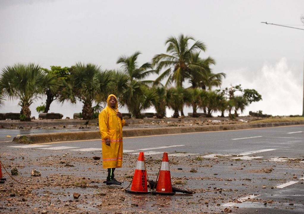 Un hombre bloquea una carretera este martes durante el paso del huracán Beryl en el malecón de Santo Domingo, República Dominicana. EFE/ Orlando Barria.