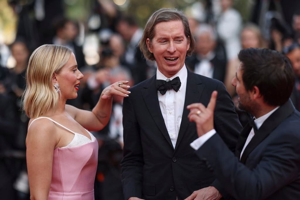 Scarlett Johansson, de izquierda a derecha, el director Wes Anderson y Jason Schwartzman posan a su llegada a al estreno de la película 'Asteroid City' en la 76a edición del festival internacional de cine de Cannes, en el sur de Francia, el martes 23 de mayo de 2023. (Foto Vianney Le Caer/Invision/AP)