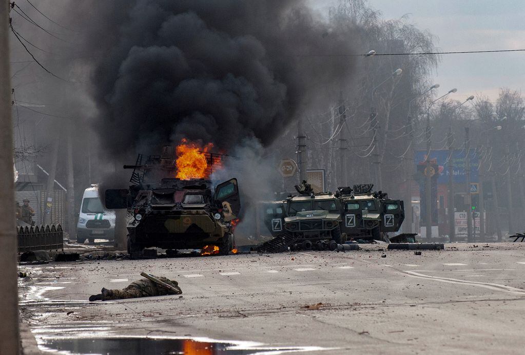 Un vehículo blindado de transporte de personal ruso arde en medio de vehículos utilitarios ligeros dañados y abandonados después de los combates en Kharkiv. (AP)