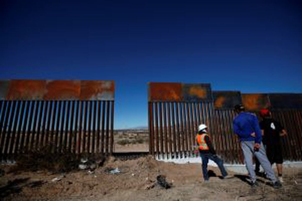A worker chats with residents at a newly built section of the U.S.-Mexico border fence at Sunland Park, U.S. opposite the Mexican border city of Ciudad Juarez, Mexico January 26, 2017. REUTERS/Jose Luis Gonzalez