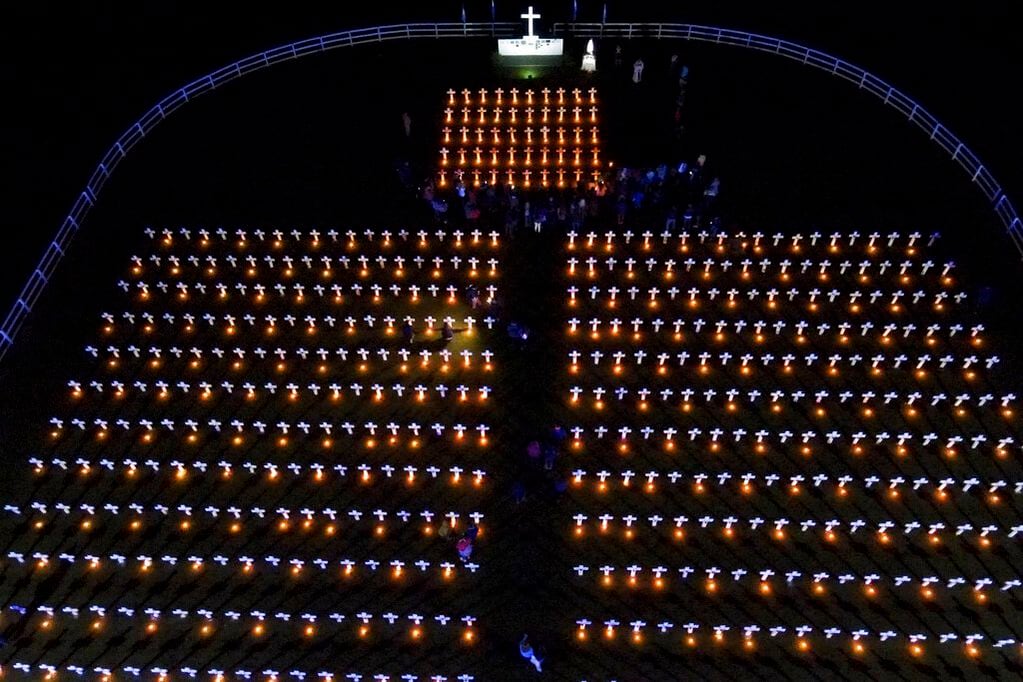 Velas iluminan cruces en un campo durante un acto para recordar a los soldados argentinos que murieron en la guerra de las Malvinas, en el 40mo aniversario del conflicto entre Argentina y Gran Bretaña por el remoto archipiélago del Atlántico sur, en Pilar, Argentina, el 2 de abril de 2022. (AP Foto/Natacha Pisarenko)