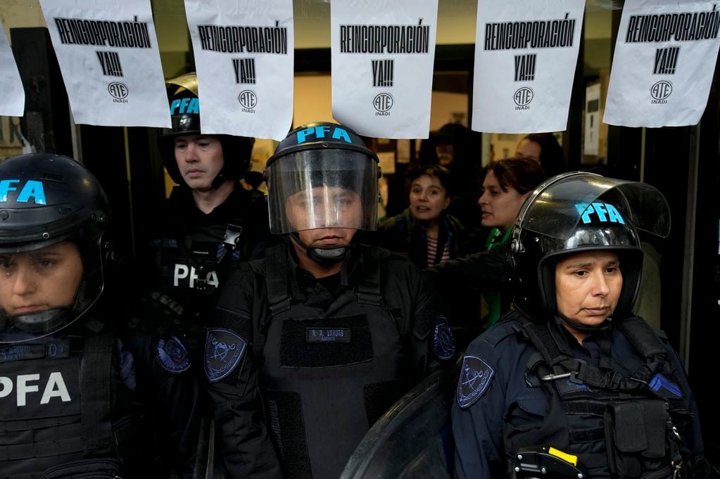 La policía hace guardia fuera del Instituto Nacional contra la Discriminación, la Xenofobia y el Racismo (INADI) para impedir la entrada de trabajadores que fueron despedidos en Buenos Aires. Foto: Head Topics