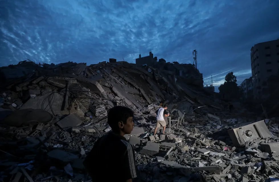 Menores inspeccionan los alrededores destruidos de la Torre Palestina después de que aviones de combate israelíes la atacaran en la ciudad de Gaza, el 7 de octubre de 2023.  EFE/ Mohammed Saber