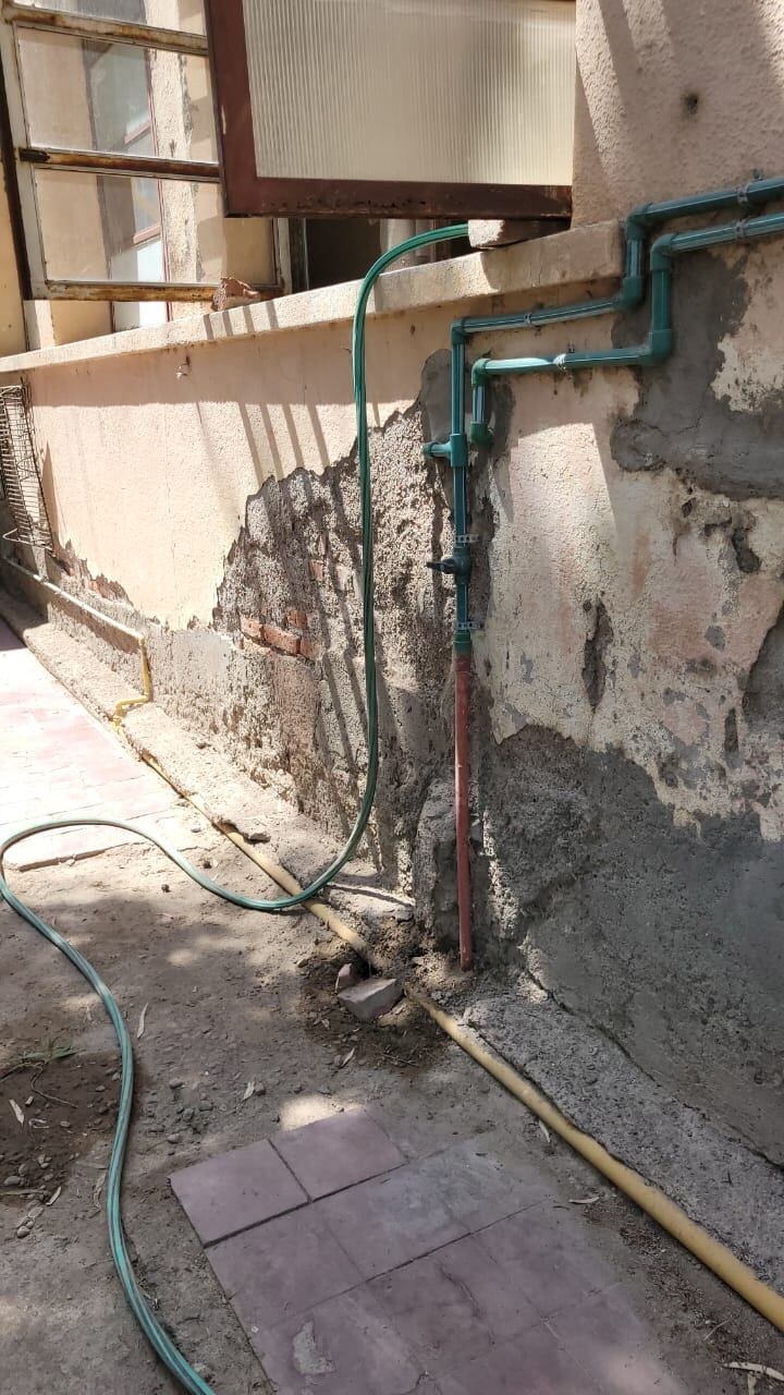 Por falta de presion de agua, el tanque de la escuella moyano no llega a cocina ni bebederos. Conectan una manguera a la red subterránea. Foto: Gentileza