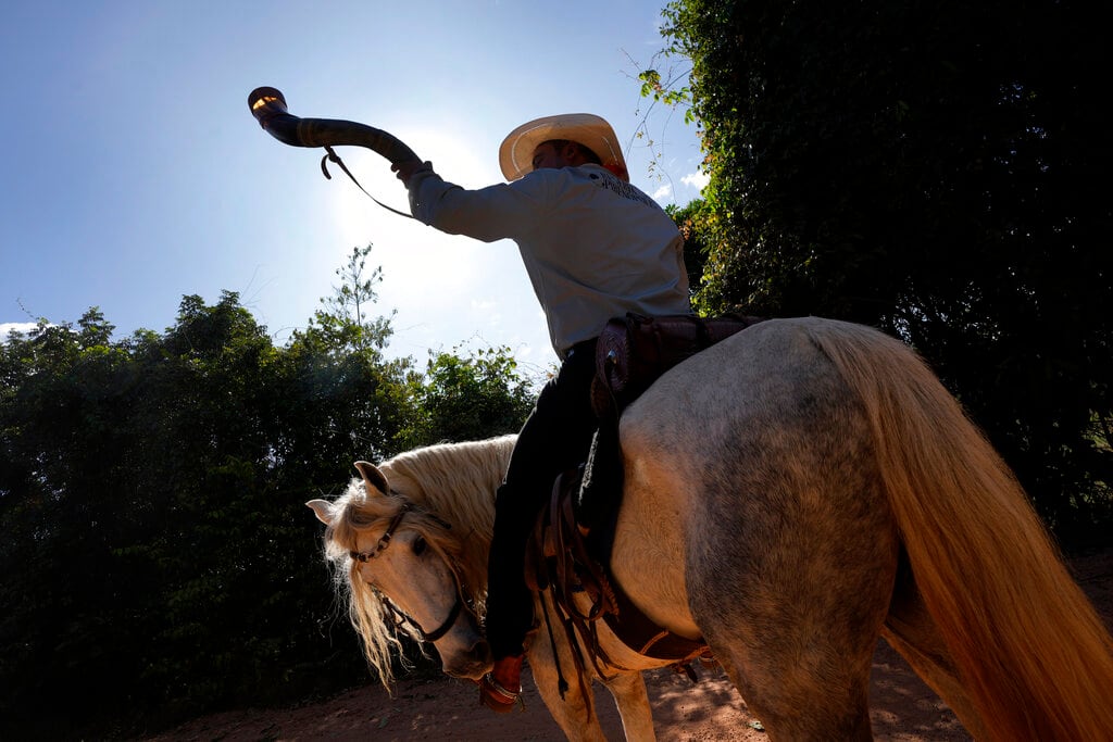 Un hombre a caballo durante un desfile por la tradición religiosa "Fiesta del Divino Espíritu Santo", en Pirenópolis, en el estado de Goias, Brasil, el sábado 28 de mayo de 2022. (AP Foto/Eraldo Peres)