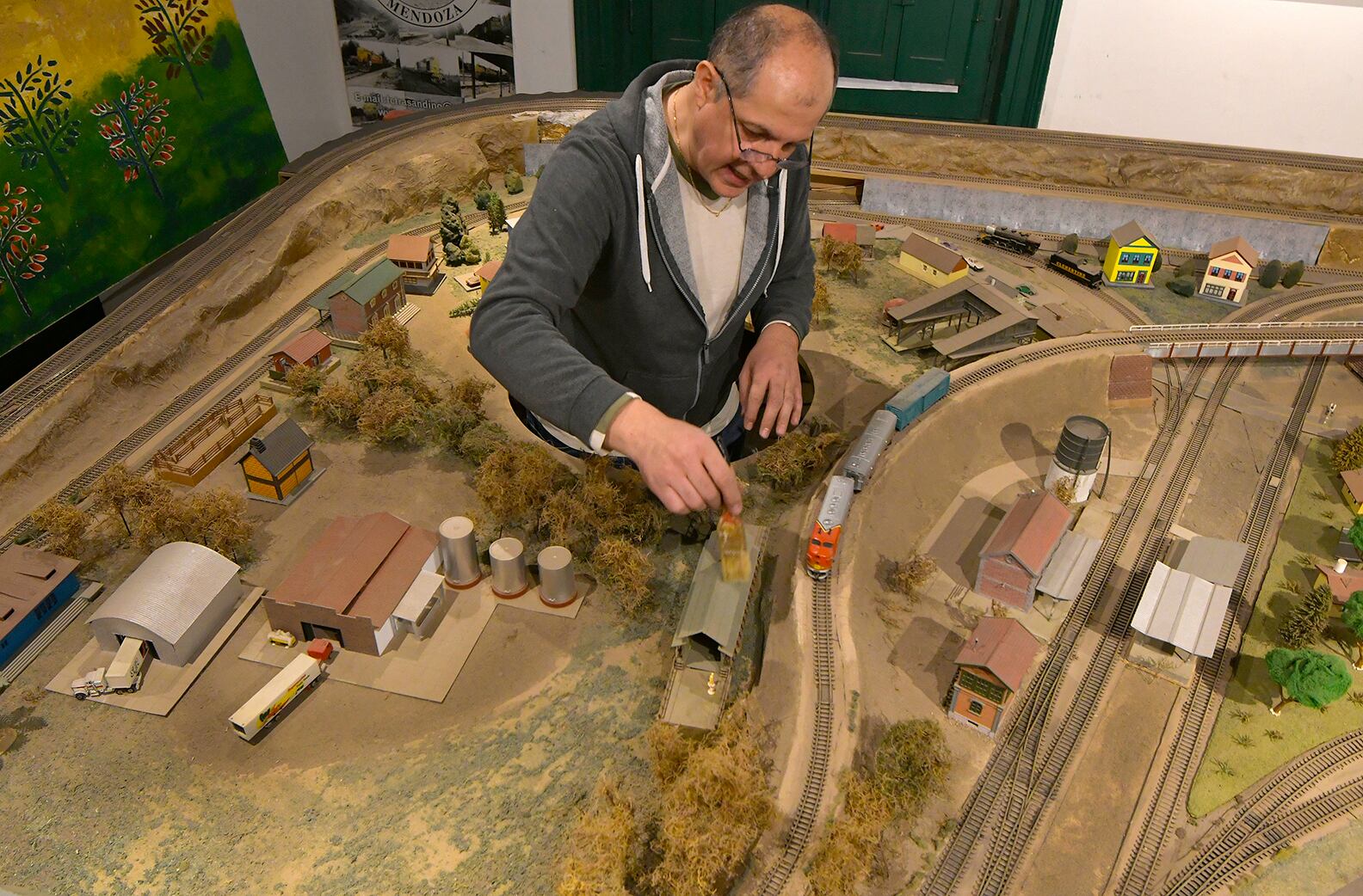 El coleccionista de trenes a escala Rubén Adrián Lépez, terminando de reparar los casi 90 metros de vías que posee la maqueta. Foto: Orlando Pelichotti