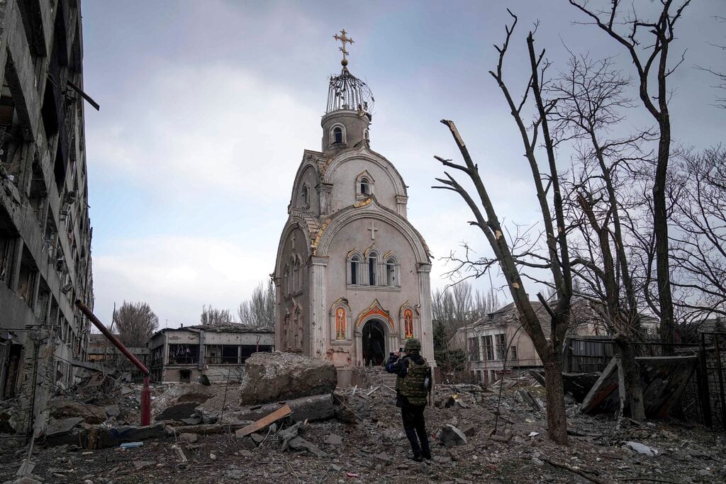 Un soldado ucraniano toma una fotografía de una iglesia dañada tras un bombardeo sobre un distrito residencial en Mariúpol, Ucrania. Foto: AP / Evgeniy Maloletka