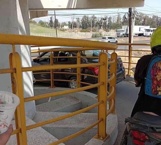 Imágenes del Versa atascado en el puente peatonal. Foto: Redes