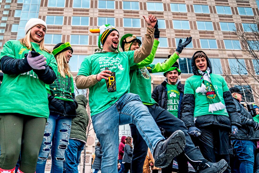 Asistentes bailan y cantan durante el Desfile del Día de San Patricio de Pittsburgh en Grant Street en Pittsburgh. (AP)