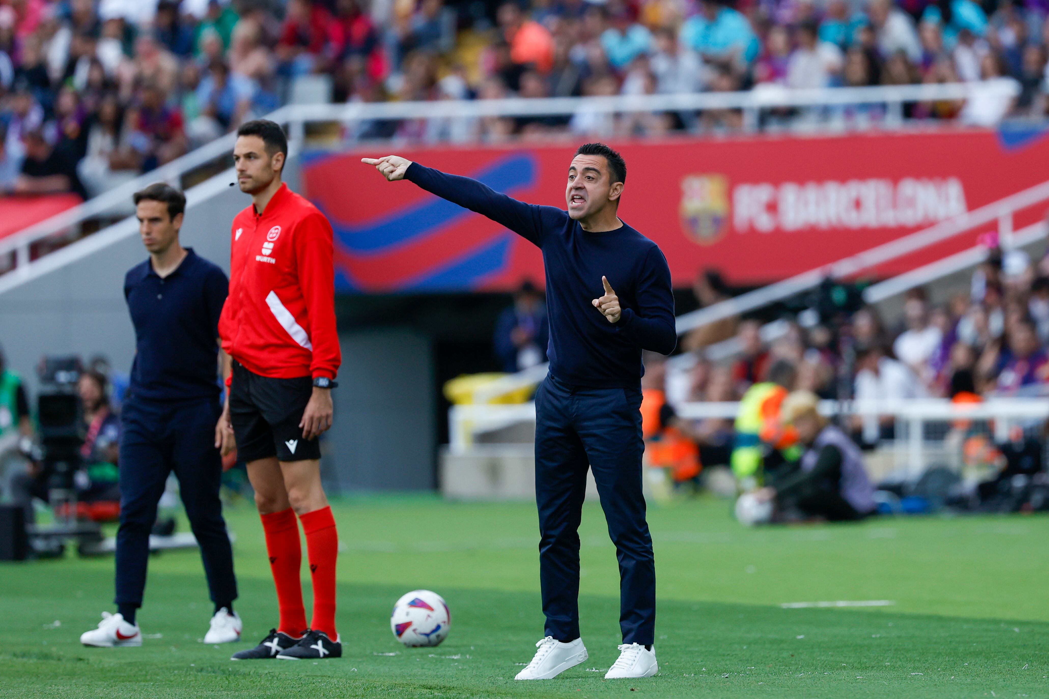 El entrenador del Barcelona, Xavi Hernández (centro), da órdenes a sus jugadores durante un partido de Liga contra el Rayo Vallecano, en el Estadio Olímpico Lluis Companys, en Barcelona, el 19 de mayo de 2024. (AP Foto/Joan Monfort)