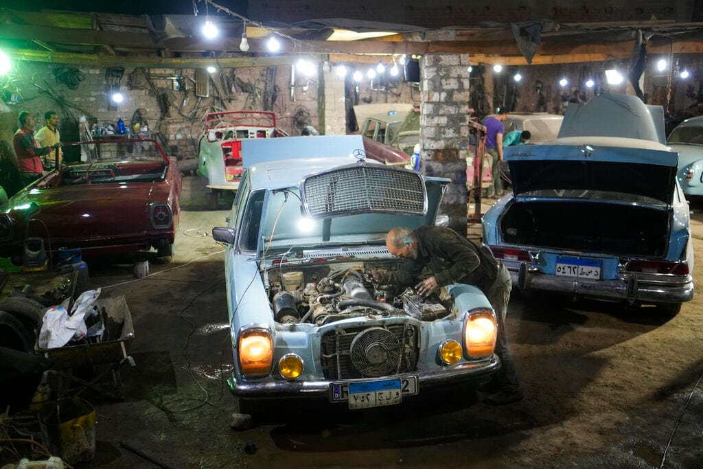 Mecánicos restauran un Mercedes de 1976 en el lote de un coleccionista de vehículos el viernes 8 de abril de 2022, en la ciudad de El Saff, gobernación de Giza, en las afueras de El Cairo. Mohamed Wahdan, un empresario egipcio y coleccionista de automóviles clásicos, dice haber acumulado más de 250 coches antiguos y clásicos en los últimos 20 años. (AP Foto/Amr Nabil)