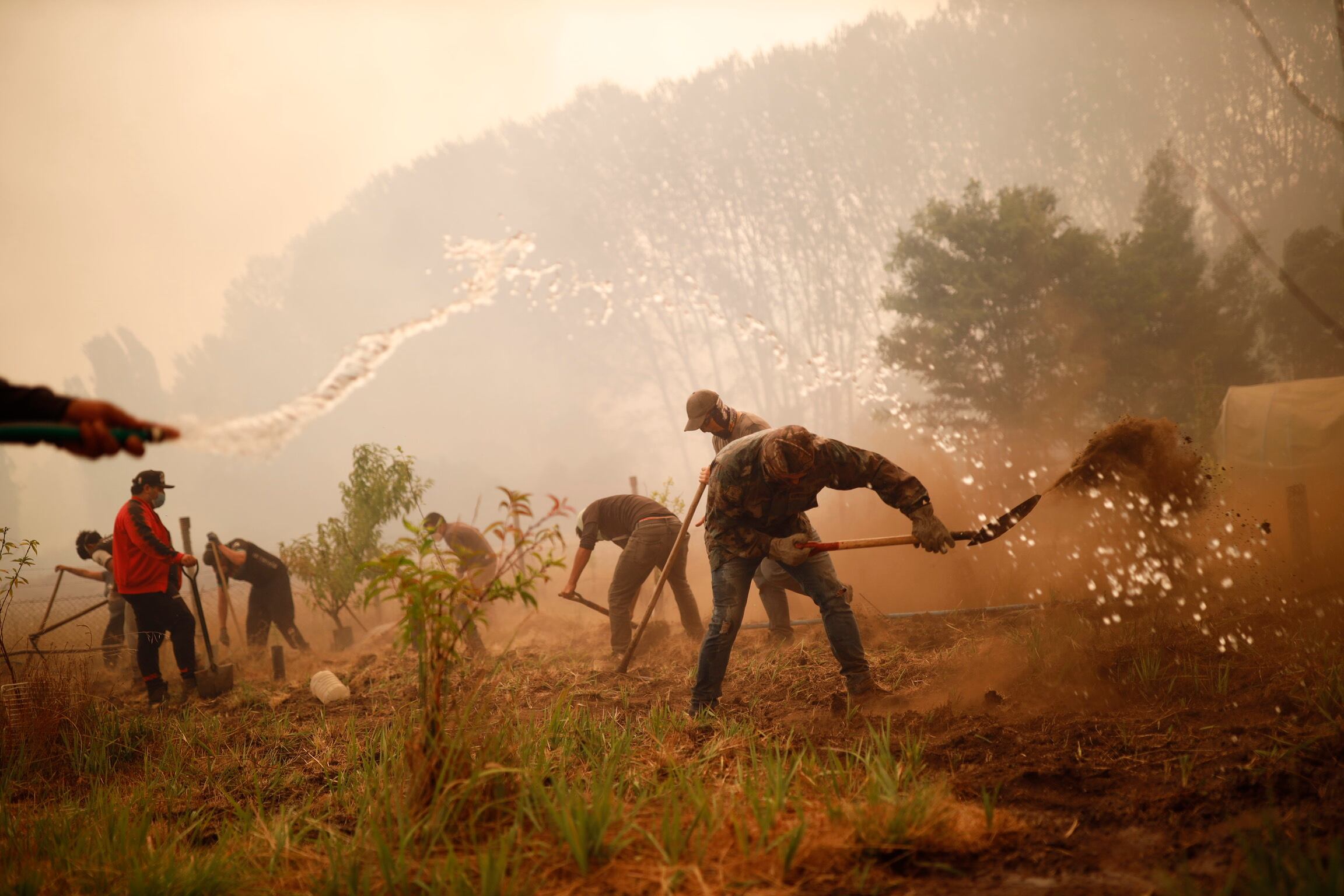 Bomberos y habitantes trabajan en apagar un incendio en Santa Juana (Chile). EFE