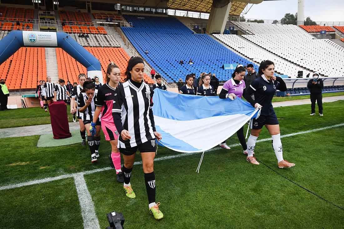 Con la bandera argentina los equipos entran a la cancha.