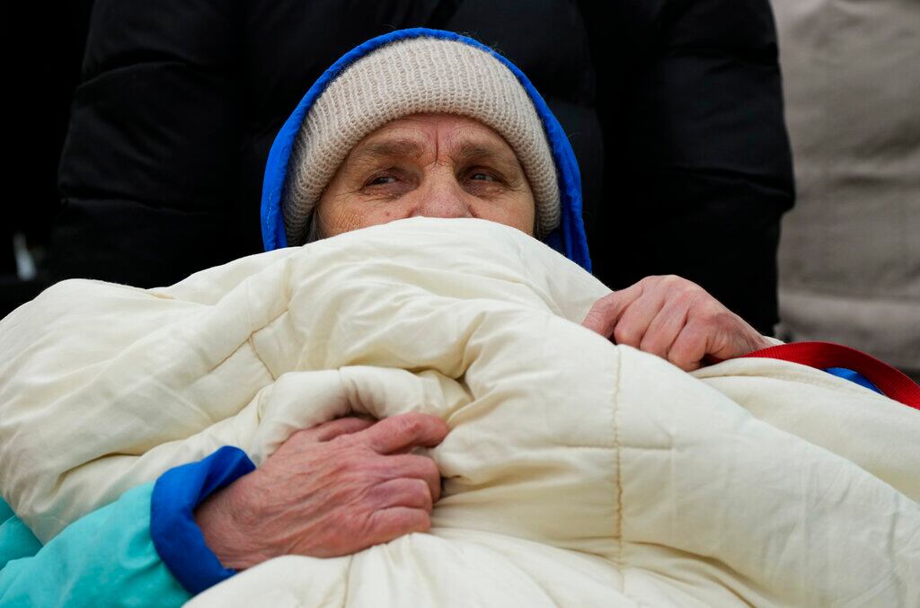 Un hombre se tapa con una cobija mientras espera en una fila después de huir de la guerra en Ucrania, en el cruce fronterizo en Medyka, sureste de Polonia, el martes 29 de marzo de 2022.  Más de 5 millones de refugiados han huido de Ucrania desde que inició la guerra de Rusia, informó la agencia de refugiados de la ONU el 20 de abril de 2022. Es la mayor crisis de refugiados en Europa desde la Segunda Guerra Mundial. (AP Foto/Sergei Grits, FILE)