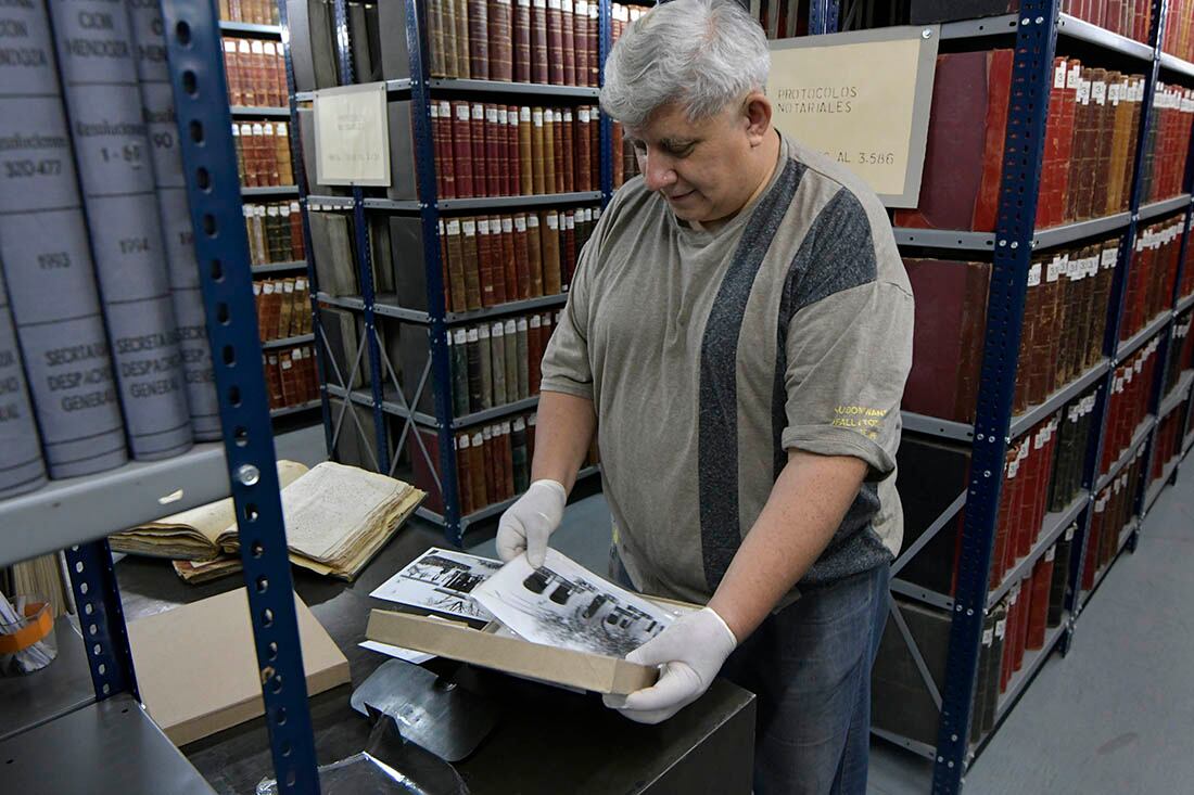 El técnico en documentación Fabian Gustavo López, manipulando fotografías del 1900.