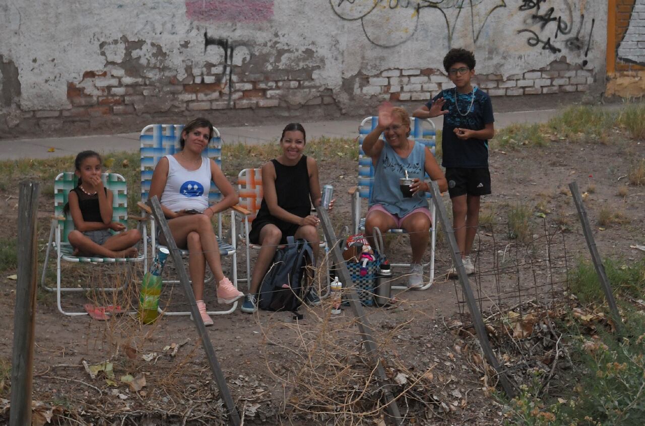 Algunos vecinos decidieron colocarse junto al canal para tener una mejor visión de la fiesta, junto con mate y familia.
Foto: Marcelo Rolland / Los Andes

