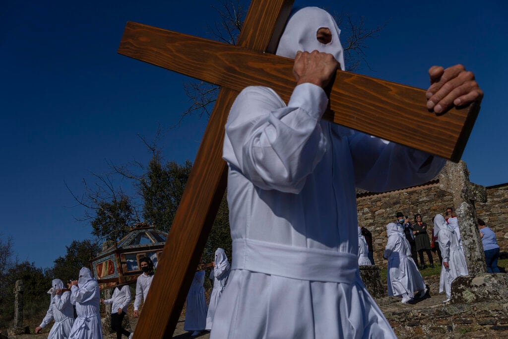 Penitentes de la cofradía El Santo Entierro durante una procesión en Bercianos de Aliste, en el noroeste de España, el 15 de abril de 2022. (AP Foto/Bernat Armangué)