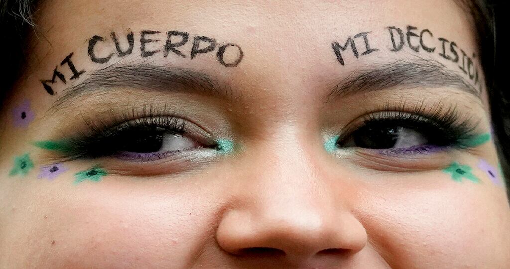 Una activista proaborto, con la frase "Mi cuerpo mi decisión" pintada sobre las cejas, durante una manifestación en el exterior de la Corte Constitucional donde los jueces discuten la despenalización del aborto, en Bogotá, Colombia, el 9 de febrero de 2022. (AP Foto/Fernando Vergara)