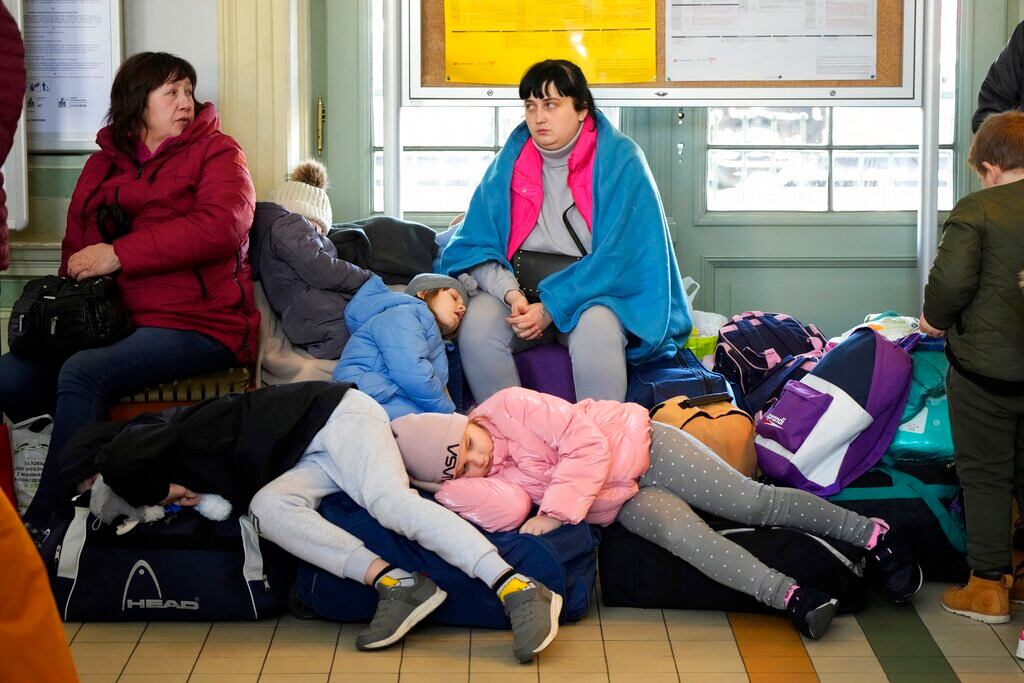 Niños ucranianos duermen sobre equipaje en una estación de trenes en Przemysl, sureste de Polonia, el miércoles 23 de marzo de 2022. Más de 5 millones de refugiados han huido de Ucrania desde que inició la guerra de Rusia, informó la agencia de refugiados de la ONU el 20 de abril de 2022. Es la mayor crisis de refugiados en Europa desde la Segunda Guerra Mundial. (AP Foto/Sergei Grits, File)