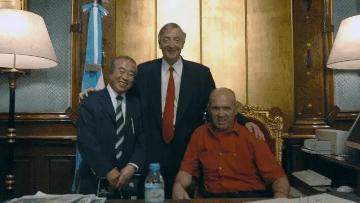 Roberto Vassie (sentado) junto al fotógrafo Ki Chul Bae (izquierda) y el ex presidente Néstor Kirchner.