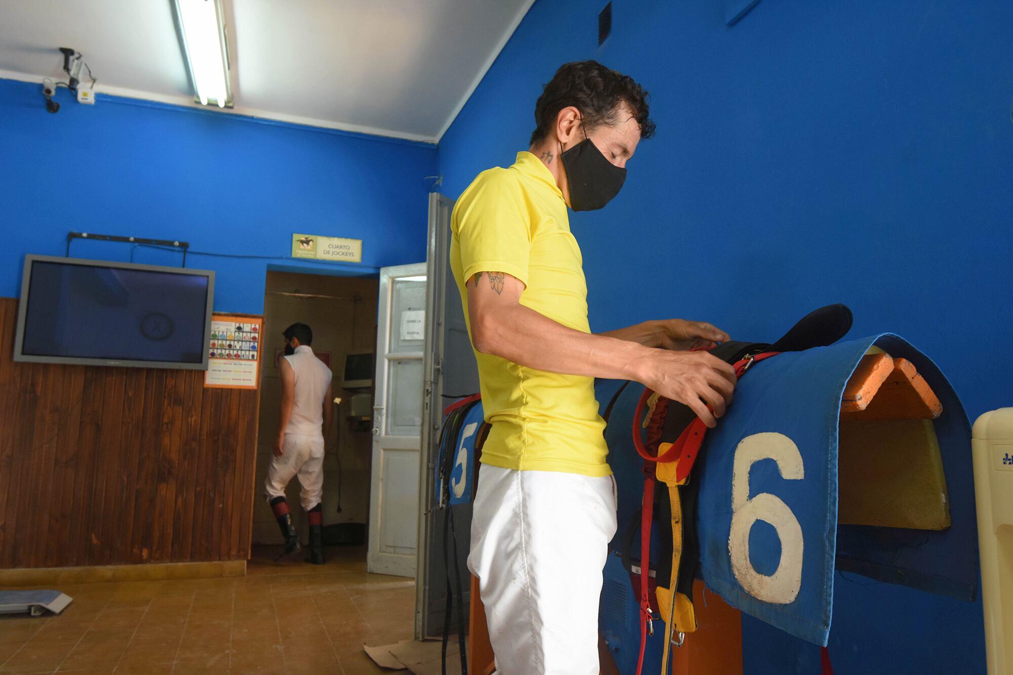 Respetando el protocolo impuesto los jinetes buscan los elementos para las carreras.