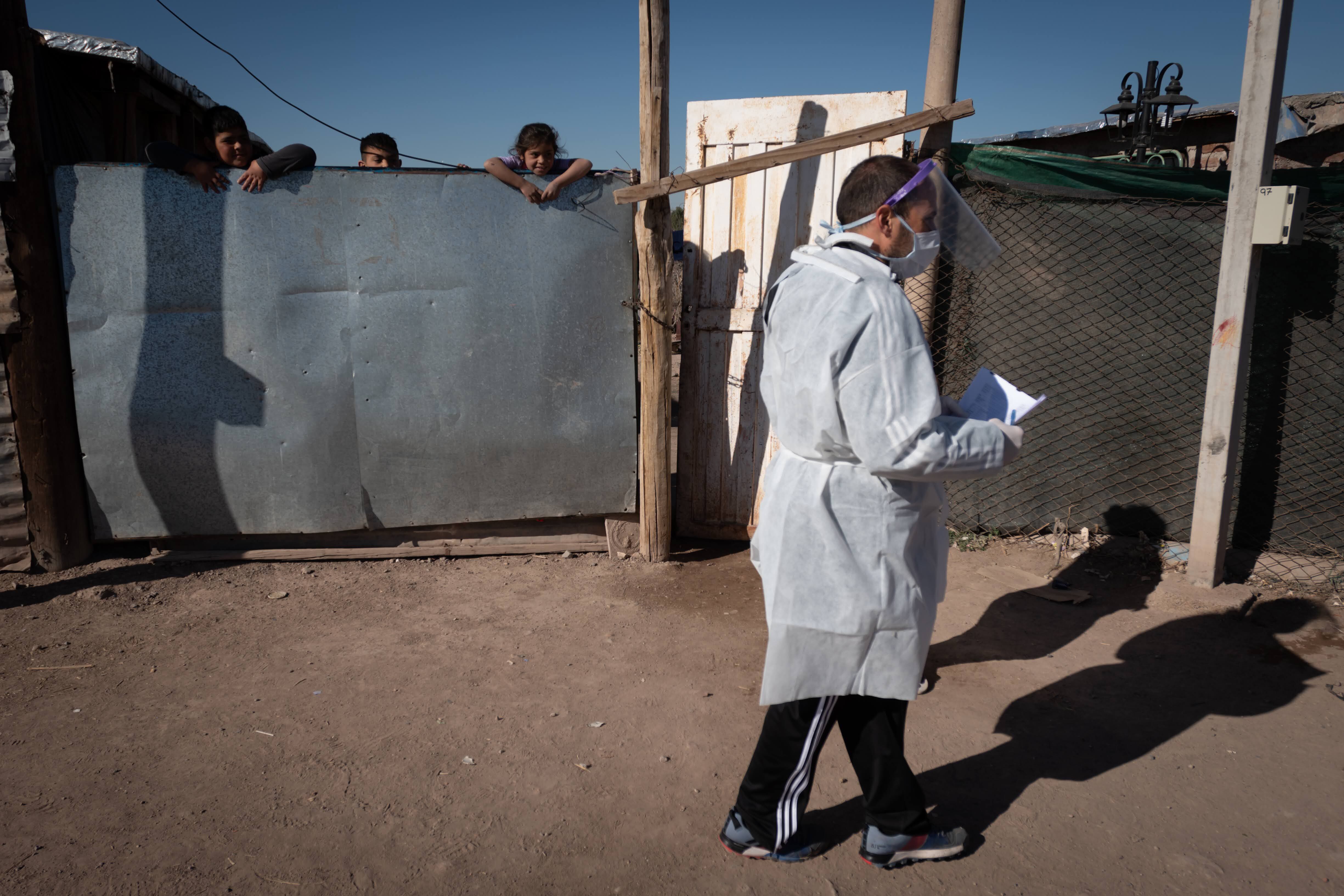 Agosto. Unos niños ven pasar al personal de sanidad mientras se realizan testeos masivos en el Barrio Campo Pappa del departamento de Godoy Cruz.