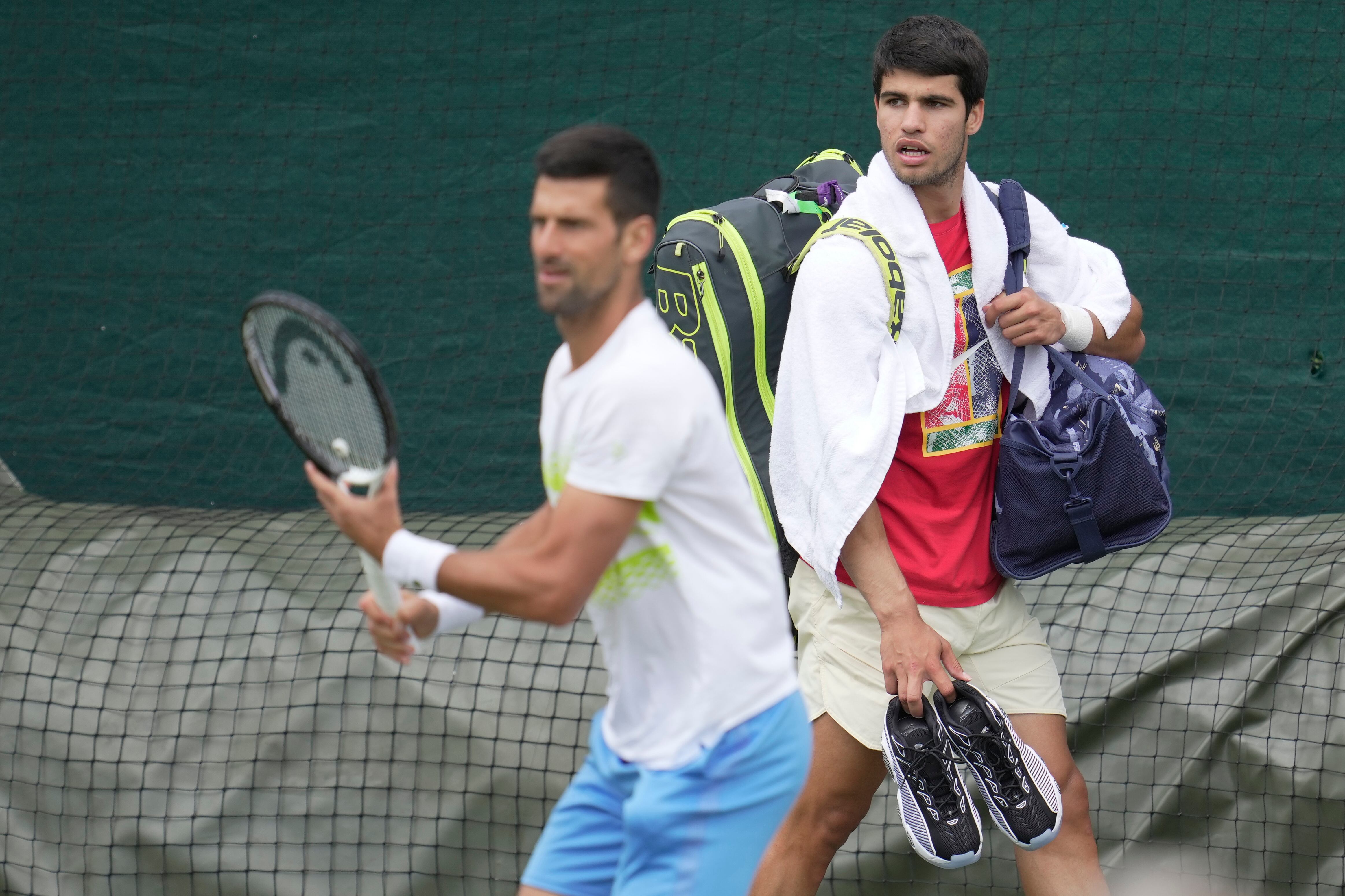 Novak Djokovic y Carlos Alcaraz durante un entrenamiento previo a Wimbledon. El serbio y el español jugarán la gran final. (AP Foto/Kin Cheung)