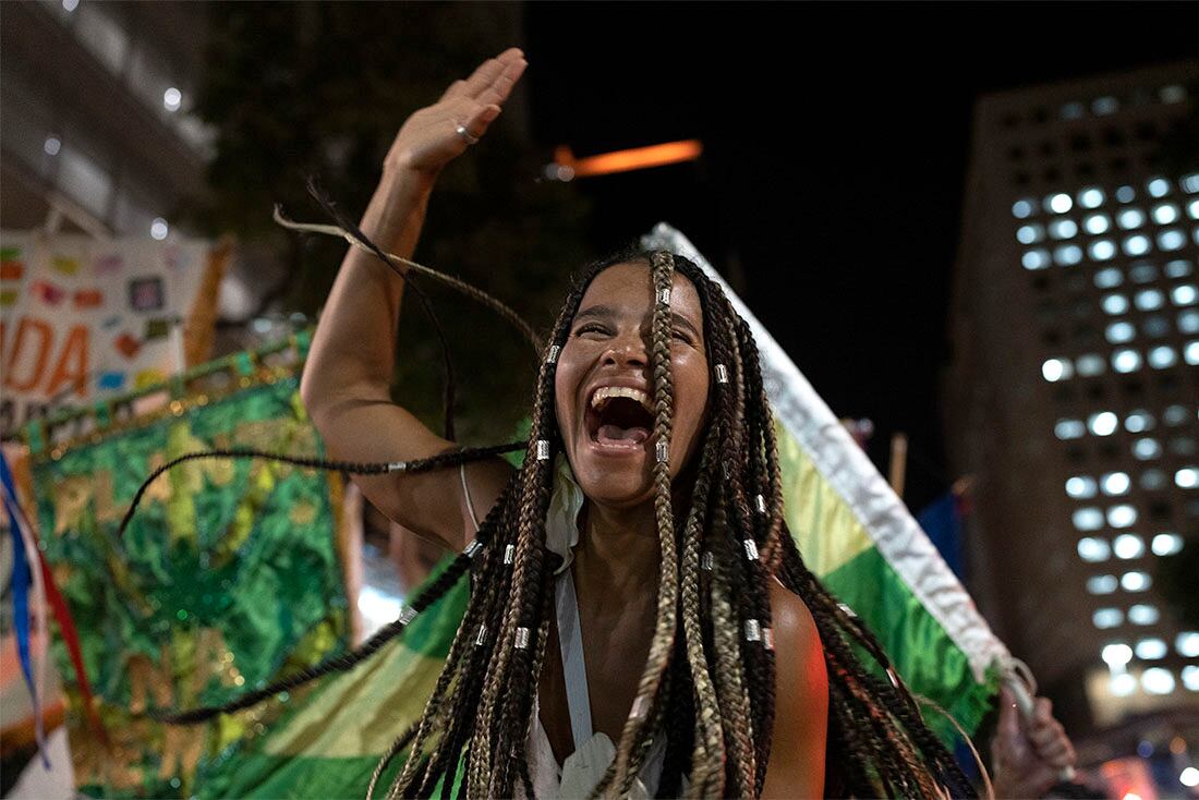 Una asistente a una fiesta callejera, o bloco, baila durante una protesta contra las restricciones impuestas por las autoridades de la ciudad de Río de Janeiro, Brasil, el 13 de abril de 2022. El ayuntamiento ha prohibido las fiestas callejeras durante el Carnaval, cuya celebración se demoró casi dos meses por la pandemia del coronavirus. (AP Foto/Silvia Izquierdo)