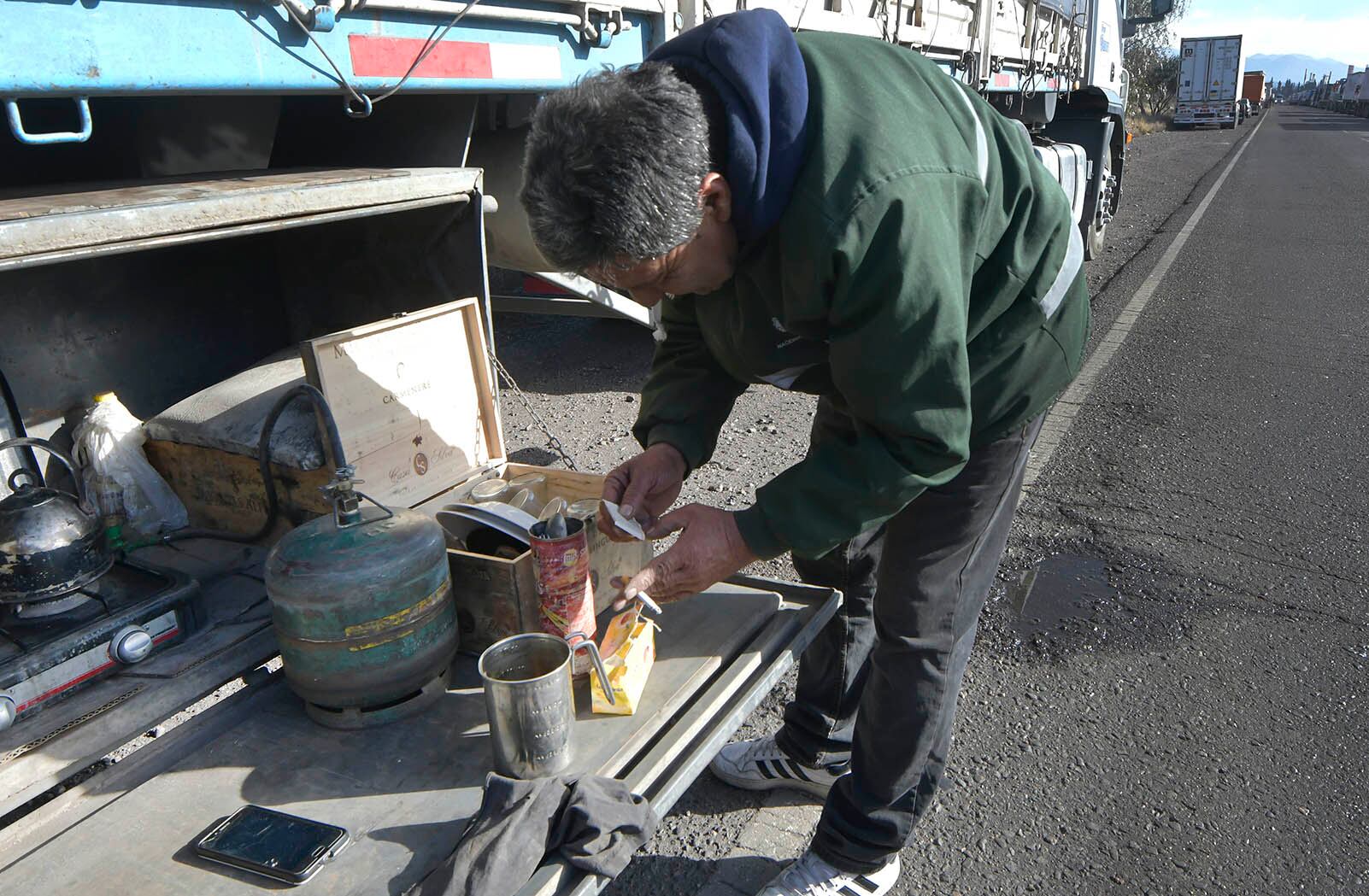 Cientos de camioneros aguardan en las playas de estacionamiento de camiones en la zonda de Destilería (en la foto, Juan Carlos Acuña, de Córdoba prepara su merienda) Foto: Orlando Pelichotti 