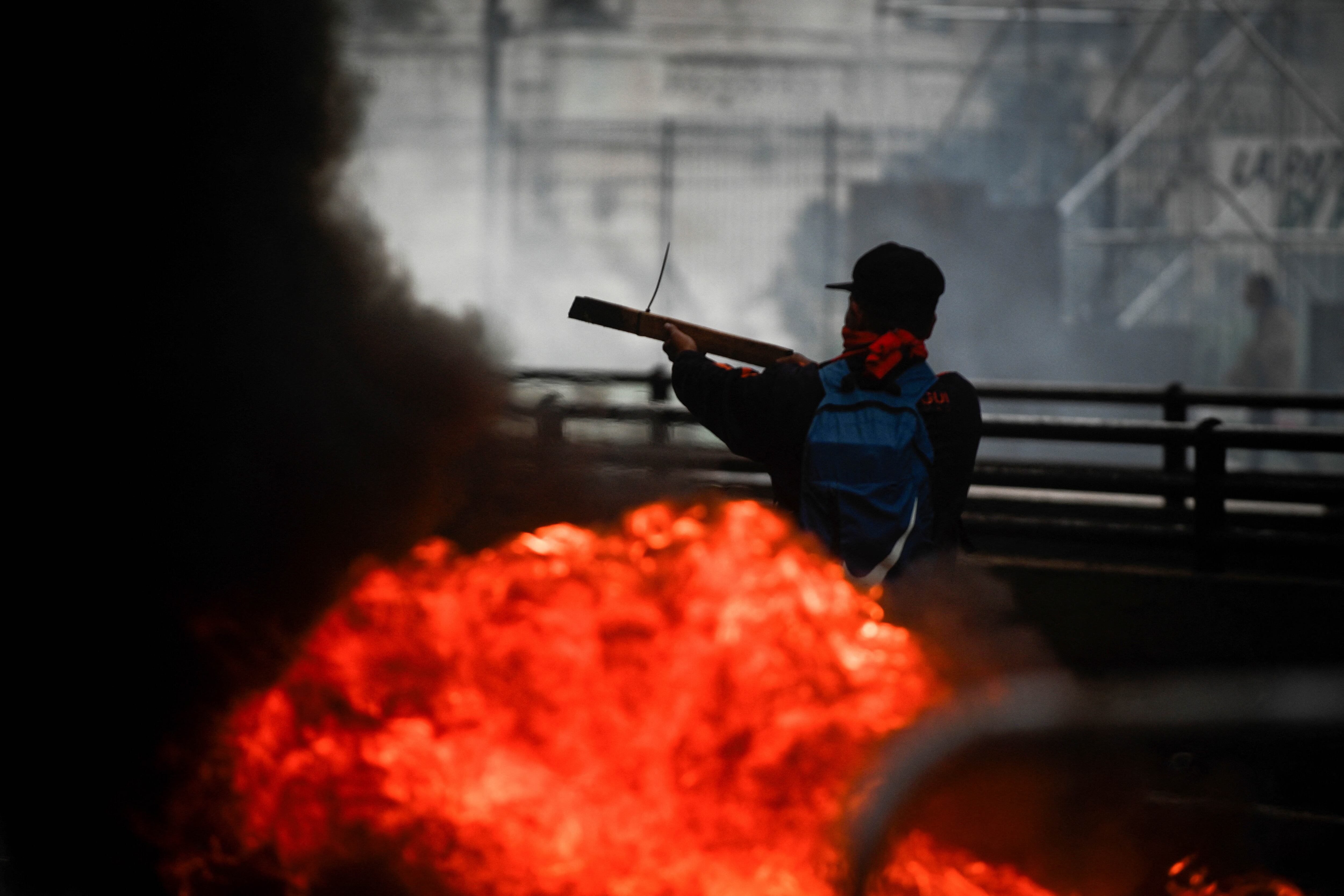 Un manifestante sostiene un trozo de madera mientras asiste a una protesta cerca del Congreso Nacional, el día en que los senadores debaten el proyecto de reforma económica del presidente argentino Javier Milei. Foto: NA/REUTERS/Mariana Nedelcuzzzz