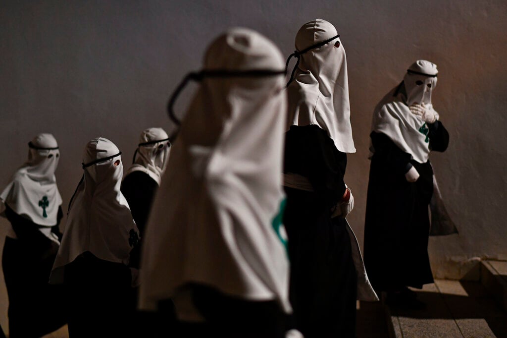 Penitentes de la cofradía de la Santa Veracruz participan en una procesión en Calahorra, en el norte de España, el 14 de abril de 2022. (AP Foto/Álvaro Barrientos)