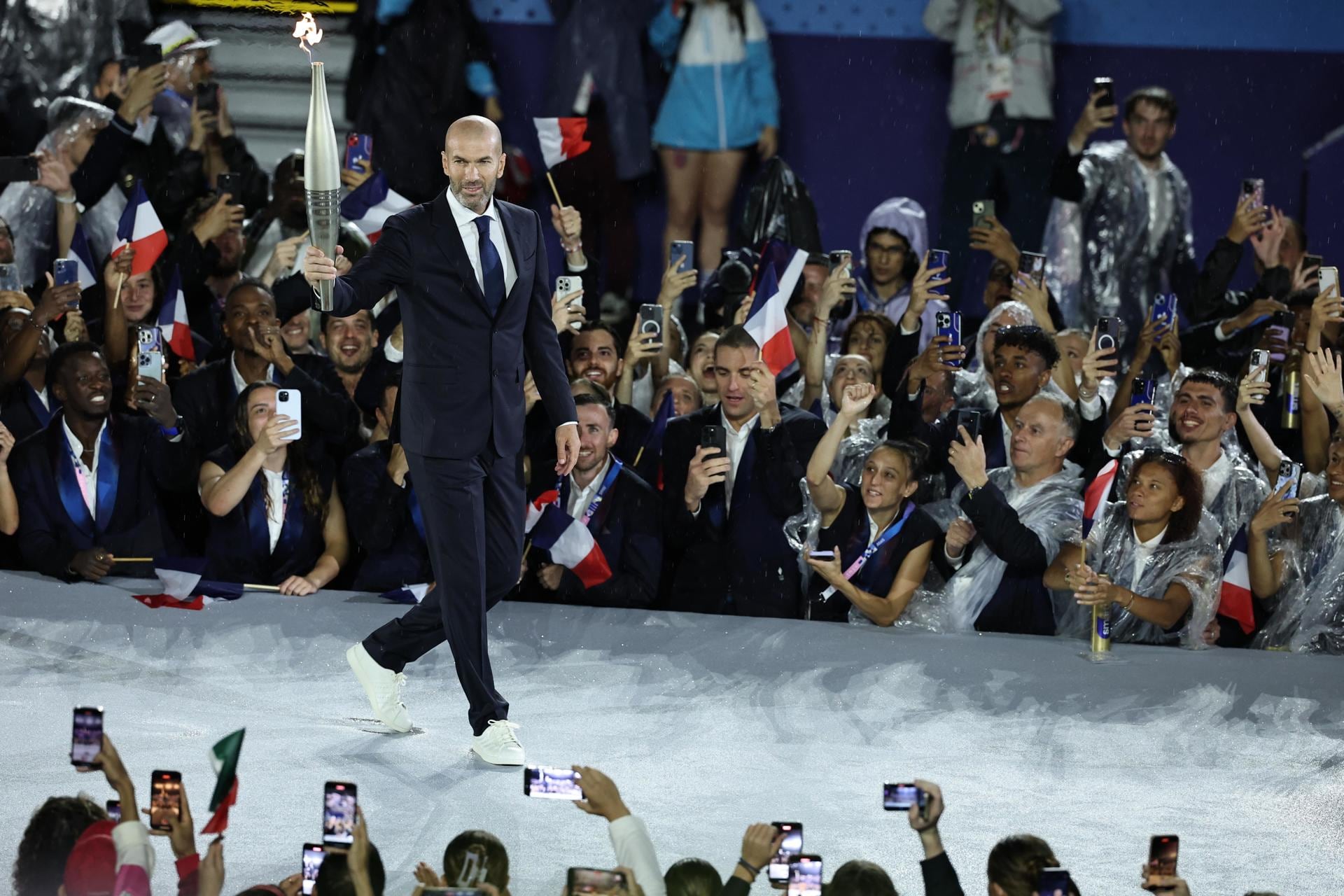 El exfutbolista francés Zinedine Zidane sostiene la antorcha olímpica durante la ceremonia inaugural de los Juegos Olímpicos de París 2024, en París, Francia. Foto: EFE/EPA/CHRISTOPHE PETIT TESSON / POOL