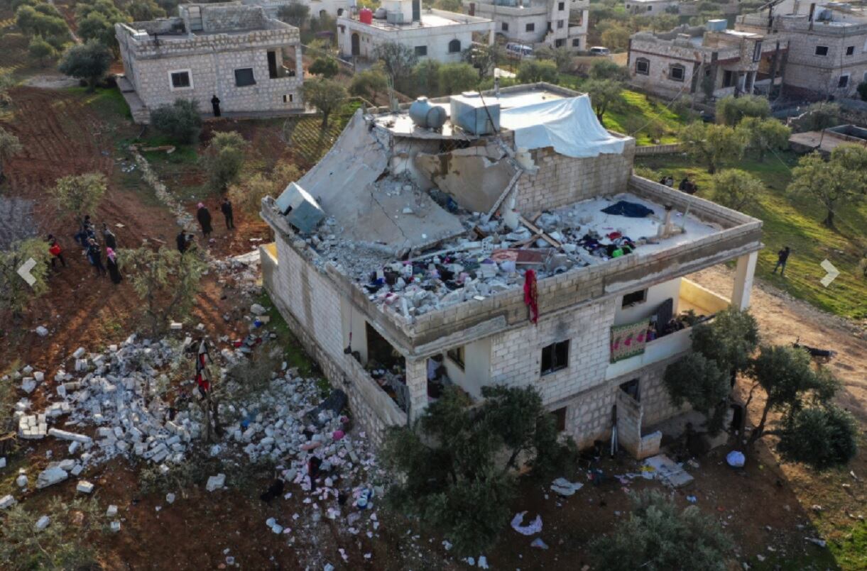 La gente inspecciona una casa destruida luego de una operación del ejército estadounidense en la aldea siria de Atmeh, en la provincia de Idlib, Siria (AP)