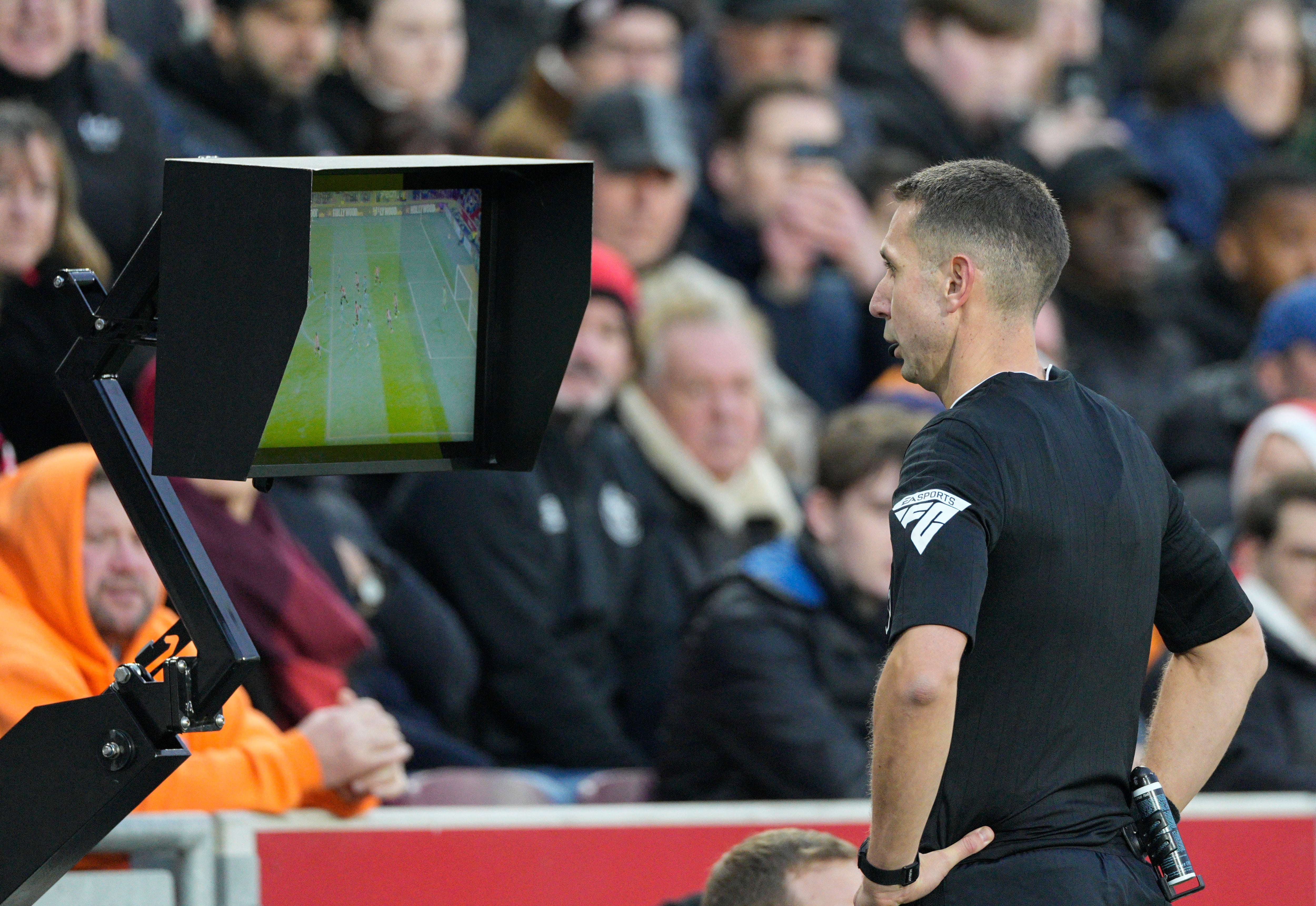 ARCHIVO - El árbitro David Coote revisa la pantalla del VAR durante el partido de la Liga Premier inglesa entre Brentford y Aston Villa, en el Gtech Community Stadium de Londres, el domingo 17 de diciembre de 2023. Claridad para jugadores y espectadores, y tolerancia cero para el juego sucio grave y la disidencia es lo que se les ha encomendado a los árbitros en la Eurocopa. (AP Foto/Dave Shopland, Archivo)