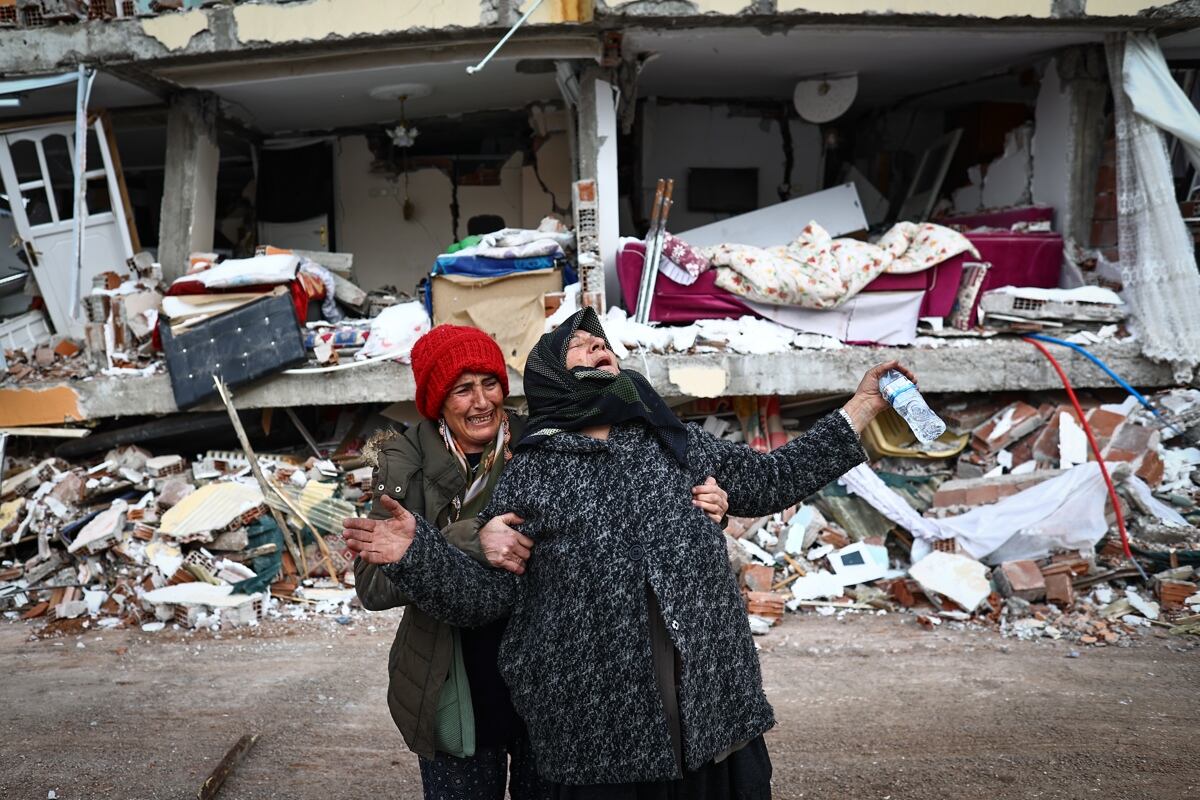 Mujeres reaccionan en el lugar de un edificio derrumbado tras un gran terremoto en el distrito de Elbistan de Kahramanmaras, Turquía (EFE)