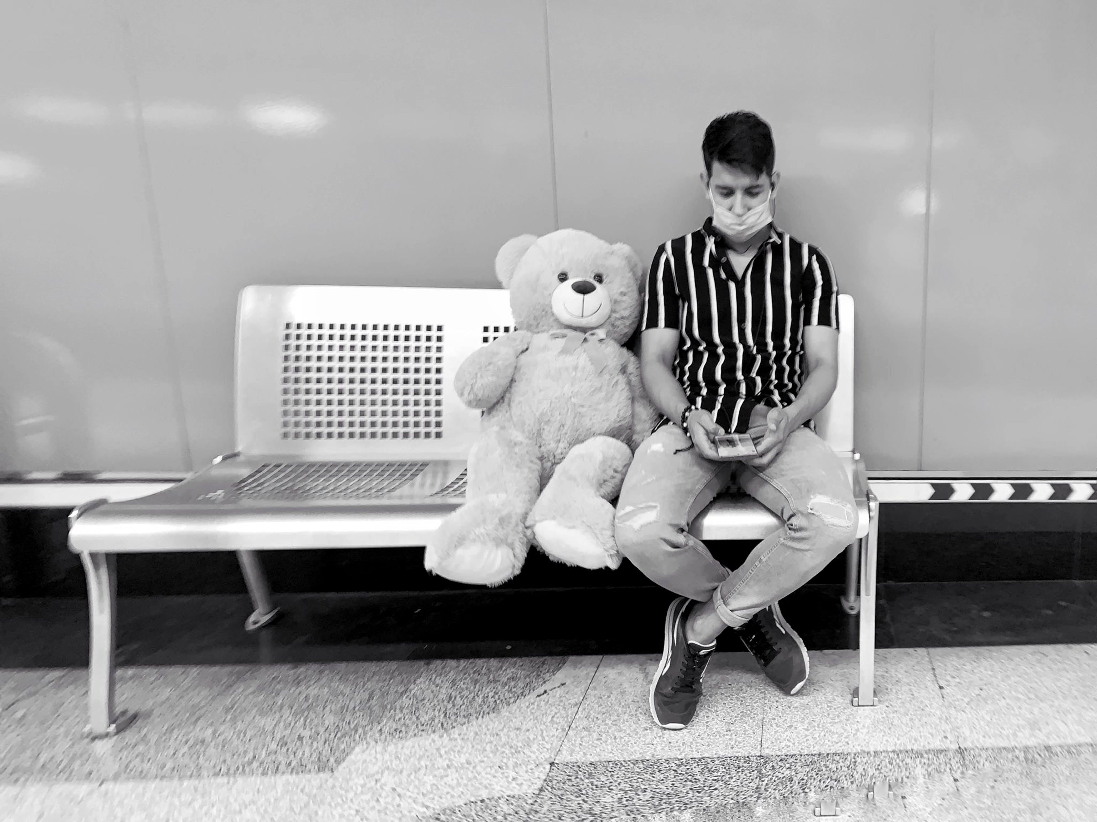 Nueva normalidad. Un muchacho y su “mascota” de peluche, en estado de espera.