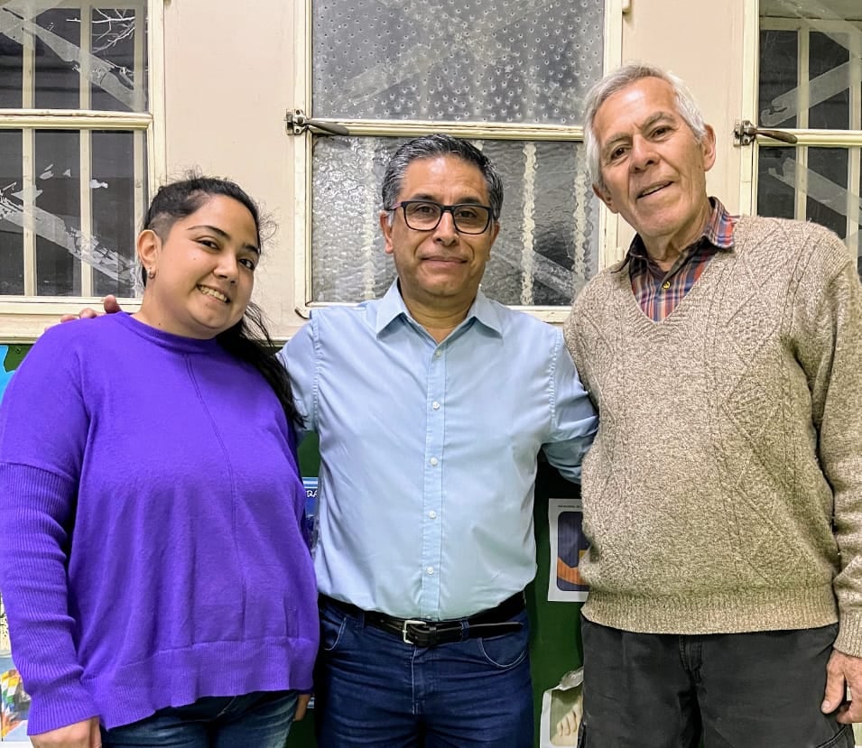 El director del CENS 3-404, Sergio Torrico, junto a Antonella, viuda y madre, y Carlos, abanderado, de 76 años.