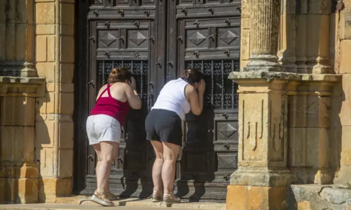 Vecinas intentan ver la fallida restauración de la ermita del Mirón. Foto: 20minutos