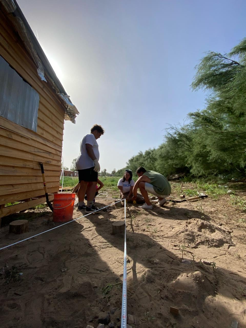 Jóvenes en plena tarea de levantar casas de emergencia.