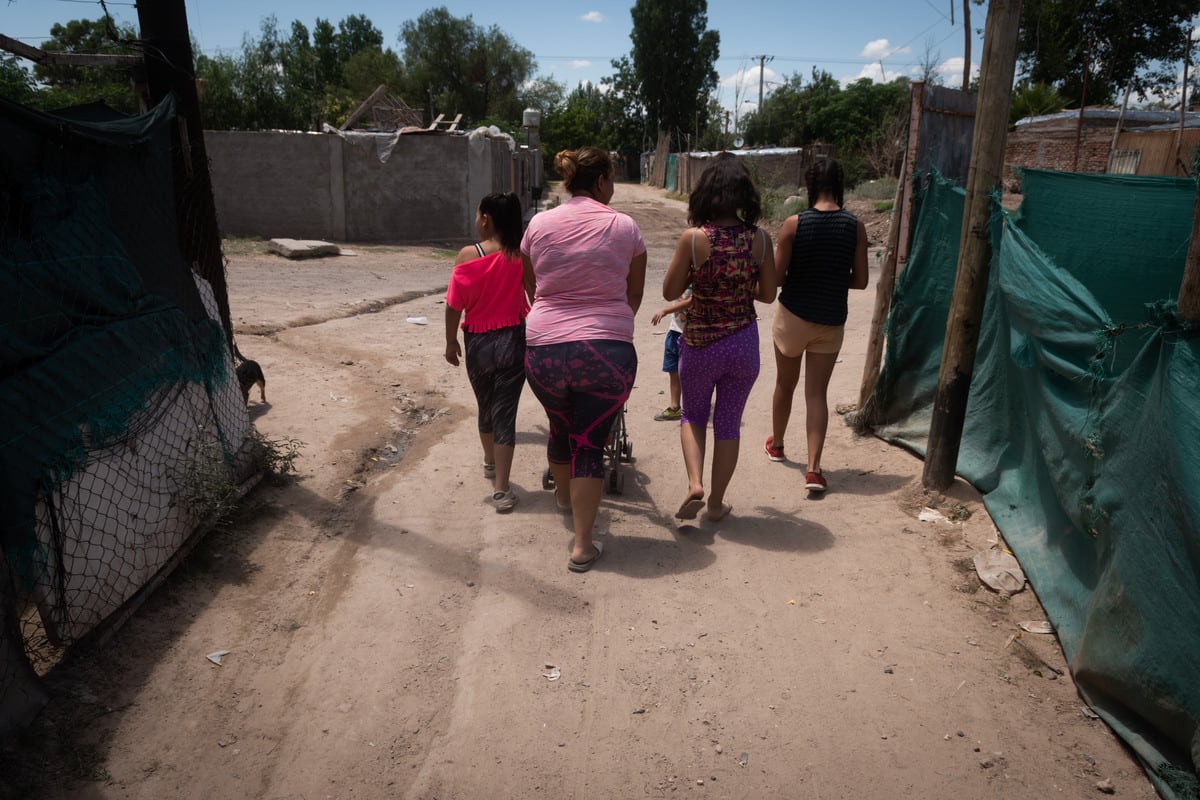 Margarita junto a sus hijos y vecinas salen en busca del bolsón de alimentos  que les darán hoy.