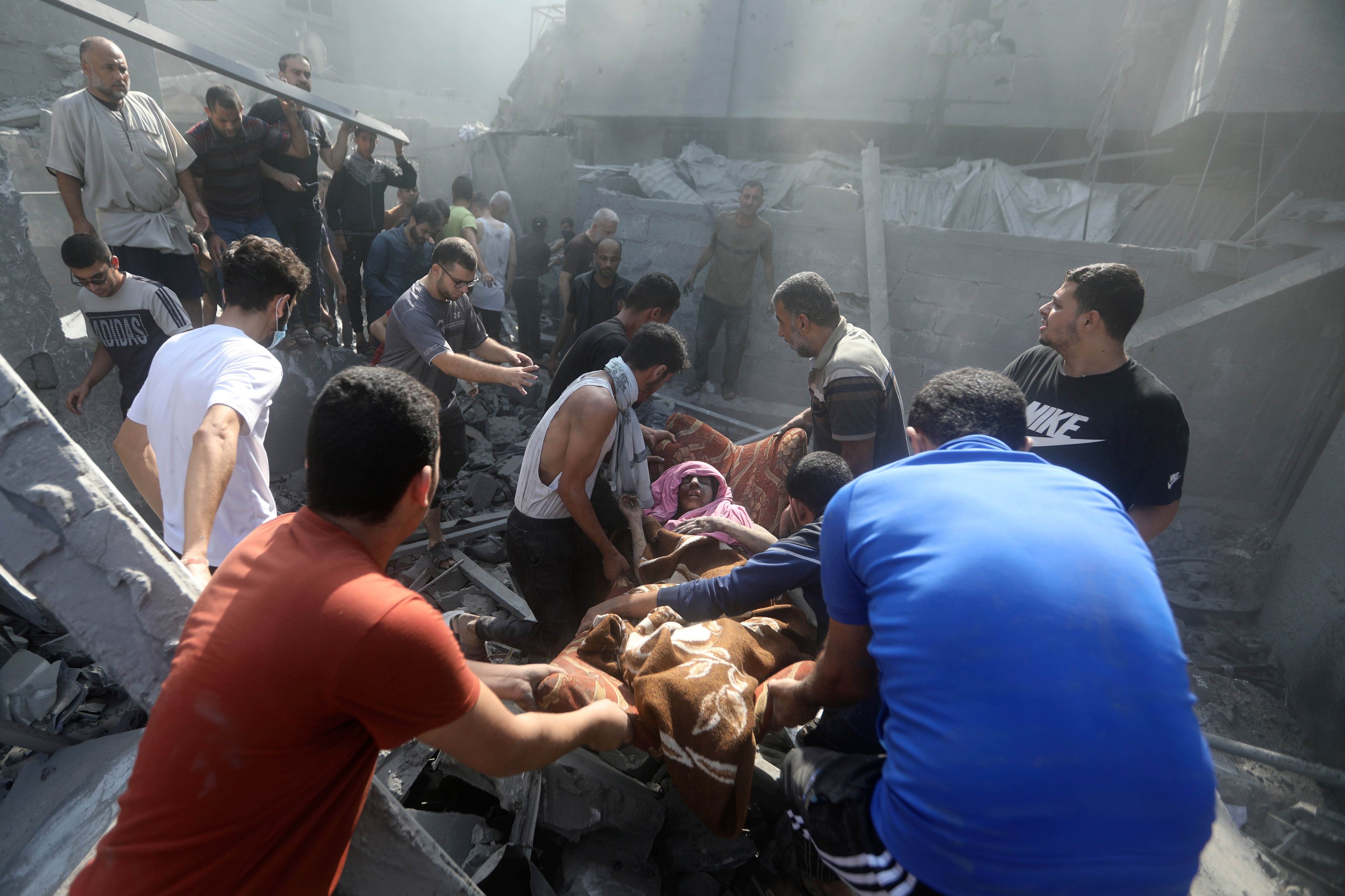 Palestinos trasladan a una mujer herida que fue rescatada de entre los escombros de un edificio destruido tras una ataque aéreo israelí sobre el campo de refugiados de Bureij, en la Franja de Gaza, el 2 de noviembre de 2023. (AP Foto/Mohammed Dahman)