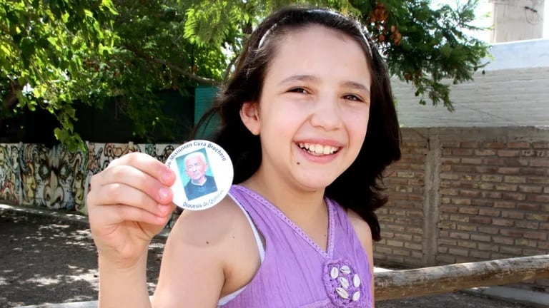 Camila Brusotti con una estampita de San Juan Gabriel Brochero en su casa de San Juan.